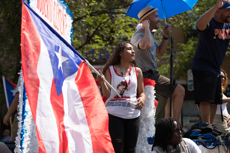 Chicago, Illinois, USA - June 16, 2018: The Puerto Rican People's Parade, Puerto rican woman waving the puerto rican flag going down the road during the paradeのeditorial素材