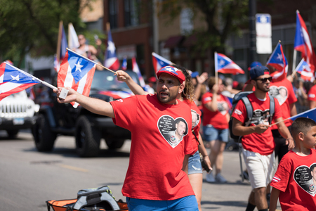 Chicago, Illinois, USA - June 16, 2018: The Puerto Rican People's Parade, Puerto Rican people carrying puerto rican flags celebrating during the paradeのeditorial素材