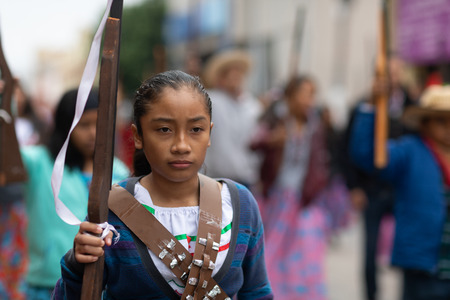 Matamoros, Tamaulipas, Mexico - November 20, 2018: The November 20 Parade, Young Girl wearing traditional clothing Holding a toy rifle at the paradeのeditorial素材