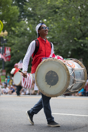 Washington, D.C., USA - July 4, 2018, The National Independence Day Parade, Man playing a large drum while walking down constitution avenueのeditorial素材