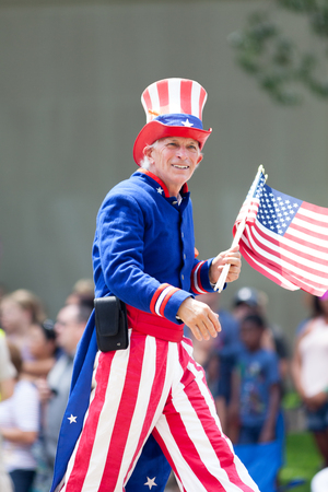 Washington, D.C., USA - July 4, 2018, The National Independence Day Parade, Man dress as Uncle Sam, waving the american flag, going down constitution avenueのeditorial素材