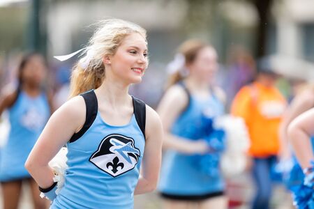 New Orleans, Louisiana, USA - February 23, 2019: Mardi Gras Parade, Cheerleader from the Academy Of Our Lady from Marrero, under the rain, smiling and dancingのeditorial素材