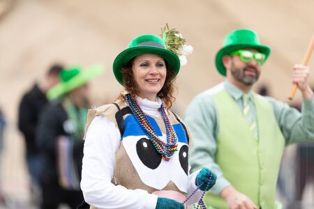 St. Louis, Missouri, USA - March 2, 2019: Bud Light Grand Parade, Woman wearing an irish hat, throwing beads to the spectatorsのeditorial素材