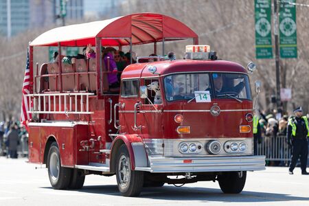 Chicago, Illinois, USA - March 16, 2019: St. Patrick's Day Parade, Old fire engine carrying families down columbus dr during the paradeのeditorial素材