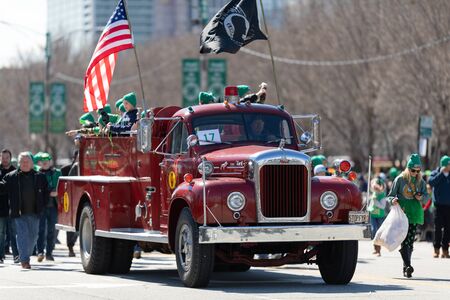 Chicago, Illinois, USA - March 16, 2019: St. Patrick's Day Parade, An old Mack Fire truck, carrying people and the american flag, driving down columbus drのeditorial素材