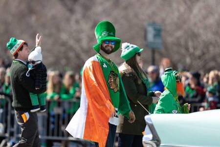 Chicago, Illinois, USA - March 16, 2019: St. Patrick's Day Parade, Man with a leprechaun hat and the irish flag on his shoulders smiles for the camera.のeditorial素材