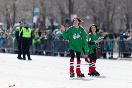Chicago, Illinois, USA - March 16, 2019: St. Patrick's Day Parade, Woman skating on columbus drive giving away shirts during the paradeのeditorial素材