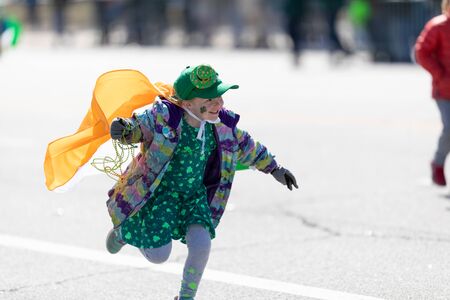 Chicago, Illinois, USA - March 16, 2019: St. Patrick's Day Parade, Child runing with the irish flag over the shoulders, with an irish hat, at the paradeのeditorial素材