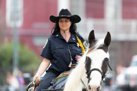 New Orleans, Louisiana, USA - February 23, 2019: Mardi Gras Parade, Female Sheriff riding a horse at...