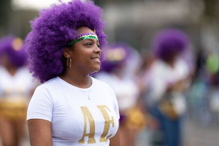 New Orleans, Louisiana, USA - February 23, 2019: Mardi Gras Parade, Alter Egos Steppers, African american dancer, wearing a purple wig, dancing during the paradeのeditorial素材