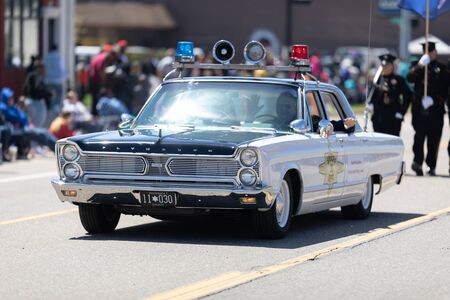 Benton Harbor, Michigan, USA - May 4, 2019: Blossomtime Festival Grand Floral Parade, Retro sheriff police car going down the road during the paradeのeditorial素材