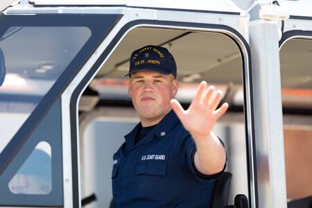 Benton Harbor, Michigan, USA - May 4, 2019: Blossomtime Festival Grand Floral Parade, Member of the U.S. Coast Guard riding in a boat during the paradeのeditorial素材
