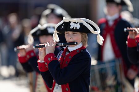 Benton Harbor, Michigan, USA - May 4, 2019: Blossomtime Festival Grand Floral Parade, Young men wearing American Revolution uniform scorting the american flagのeditorial素材