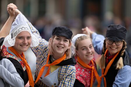 Holland, Michigan, USA - May 11, 2019: Tulip Time Festival, Young women wearing traditional Dutch Clothing dancers in the streets of Holland, Michigan posing for a photo during the Festivalのeditorial素材