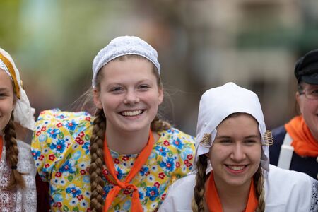 Holland, Michigan, USA - May 11, 2019: Tulip Time Festival, Young women wearing traditional Dutch Clothing dancers in the streets of Holland, Michigan posing for a photo during the Festivalのeditorial素材