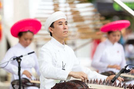 Columbus, Ohio, USA - May 26, 2019: Columbus Asian Festival, Franklin Park, Vietnamese man wearing traditional clothing playing the Dan Tranh at the asian festivalのeditorial素材
