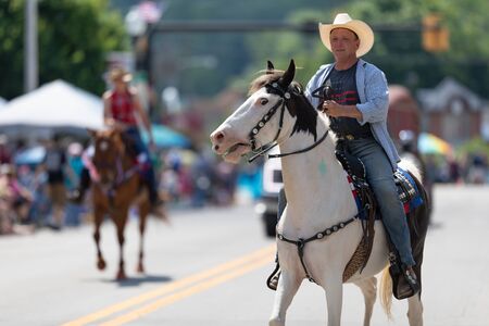 Buckhannon, West Virginia, USA - May 18, 2019: Strawberry Festival, Caucasian Man riding a white horse down the street during the paradeのeditorial素材