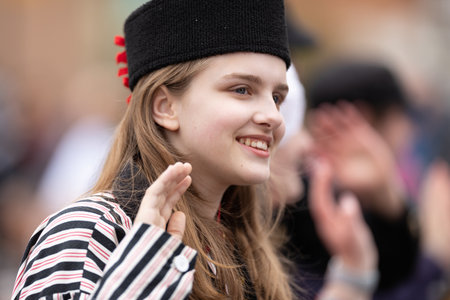Holland, Michigan, USA - May 11, 2019: Tulip Time Parade, Young woman wearing traditional dutch clothing smiling, walking down the road during the paradeのeditorial素材