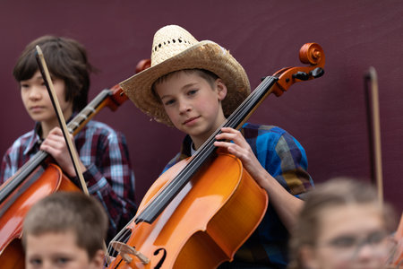 Holland, Michigan, USA - May 11, 2019: Tulip Time Parade, Young Children members of a Christian School, playing the Violoncello during the paradeのeditorial素材