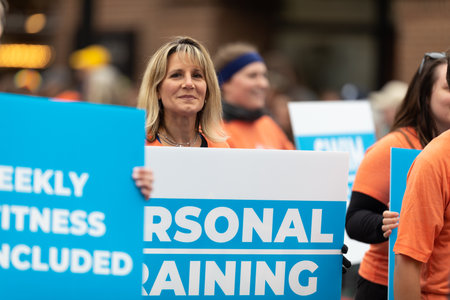 Holland, Michigan, USA - May 11, 2019: Tulip Time Parade, Woman holding a sign that says Personal training,  promoting MVP Club  during the paradeのeditorial素材