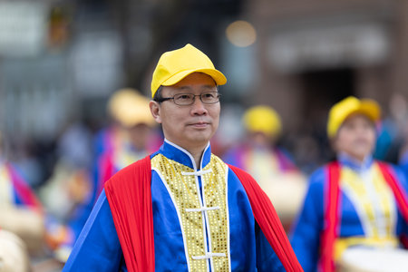Holland, Michigan, USA - May 11, 2019: Tulip Time Parade, Chinese man wearing traditional clothing , playing the drum during the paradeのeditorial素材