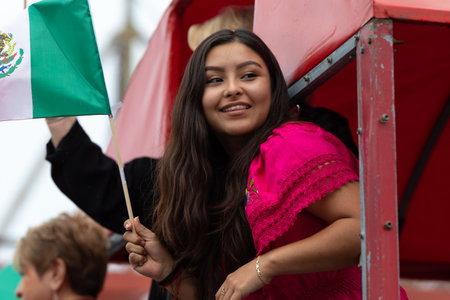 Chicago, Illinois, USA - September 8, 2019: 26th Street Mexican Independence Parade, Young woman wearing traditional clothing, on a float, waving the mexican flagのeditorial素材