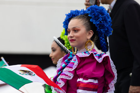 Chicago, Illinois, USA - September 8, 2019: 26th Street Mexican Independence Parade, Mexican girls, wearing traditional clothing, waving mexican flags on a float, during the paradeのeditorial素材