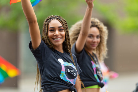 Cincinnati, Ohio, USA - June 22, 2019: The Cincinnati Pride Parade, Young women waving the rainbow...