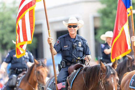 Arlington, Texas, USA - July 4, 2019: Arlington 4th of July Parade, Mounted Police Officer, carrying the American flag down the parade routeのeditorial素材