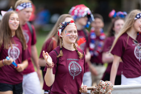 Arlington, Texas, USA - July 4, 2019: Arlington 4th of July Parade, Young women waving american flags, and wearing shirts promoting the Ulster Projectのeditorial素材
