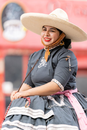 Matamoros, Tamaulipas, Mexico - September 16, 2022: Desfile 16 de Septiembre, Young woman wearing traditional clothing riding a horseのeditorial素材