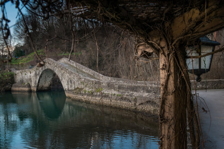 Artificial lake of Pontecosi in Garfagnana in the region of Tuscany, railroad bridge and a little church from a stone little bridgeの写真素材