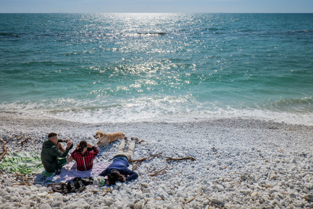 MARINA DI PISA, ITALY - Avril 24, 2017: View of the sea and the beach of white pebbles, people take the first sun of the season in Marina di Pisa Tuscanyのeditorial素材