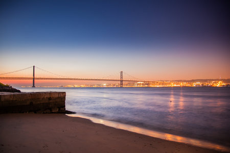LISBON, PORTUGAL - February 01, 2011: The Tagus River past the 25 de Abril bridge from Cacilhas, night falling on the docksのeditorial素材
