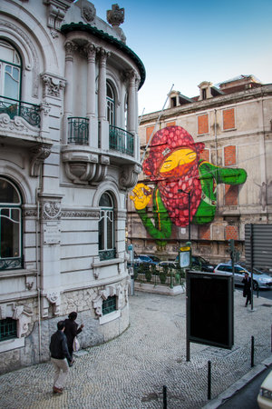LISBON, PORTUGAL - unknown person walks in Avenida Pereira, murals on buildings of ancient architecture, Lisbon, Portugalのeditorial素材