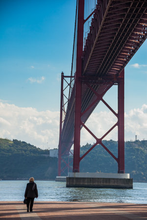 LISBON, PORTUGAL - January 28, 2011: unknown people along the banks of Tagus River in Belem and famouse bridge of 25th April over river on January 28, 2011, Lisbon, Portugalのeditorial素材