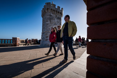 PIOMBINO, TUSCANY, ITALY - Avril 01, 2018:  Piombino, Tuscany, Italy - three unknown people walk in the Bovio square overlooking the Island of Elbaのeditorial素材