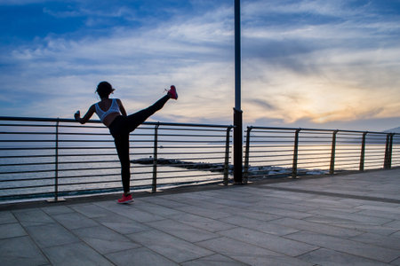 SESTRI LEVANTE, GENOA, ITALY - JUNE 1, 2018: unknown person does stretching during the sunset in...