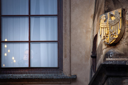 PRAGUE, CZECH REPUBLIC - FEBRUARY 19, 2013: unknown man at windows, historic buildings of the Prague Old Town Squareのeditorial素材