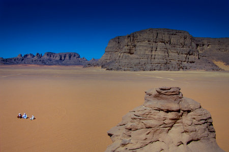 TASSILI NâAJJER, ALGERIA - JANUARY 10, 2002: Three unknown men sitting down in the sand dunes of the Algerian Sahara desert, Africa, Tassili N'Ajjer National Parkのeditorial素材