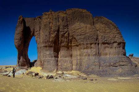 TASSILI NâAJJER, ALGERIA - JANUARY 10, 2002: Unknown man walks in the sand dunes of the Algerian Sahara desert, Africa, Tassili N'Ajjer National Parkのeditorial素材