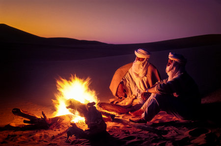 TASSILI NâAJJER, ALGERIA - JANUARY 10, 2002: unknown men at sunset with fire in the sand dunes of the Algerian Sahara desert, Africa, Tassili N'Ajjer National Parkのeditorial素材