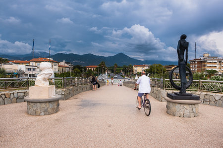 TONFANO, LUCCA, ITALY - AUGUST 13, 2018: unknown man people walk on the Tonfano pier, a work of the architect Tiziano Lera built in 2008, a seaside town with beaches by the seaのeditorial素材