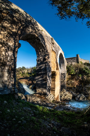 VULCI, ITALY - DECEMBER 26, 2019: The Badia bridge and castle, medieval dating back to the 13th century, an ancient Etruscan city in the territory of Canino and Montalto di Castro, in the province of Viterbo, in the Maremma of Lazio.のeditorial素材