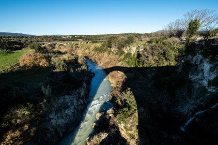 VULCI, ITALY - DECEMBER 26, 2019: shadow of the Badia bridge  over the Fiora river in Vulci, an ancient Etruscan city in the territory of Canino and Montalto di Castro, in the province of Viterbo, in the Maremma of Lazio.のeditorial素材