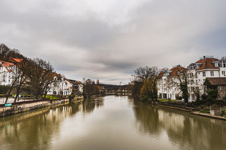 Flooding danger: River Neckar view from the Eberhardsbrucke (Eberhard Bridge) with buildings by the river banks. Wealthy German community settled by the riverbank at flood risk - Tubingen, Germanの写真素材