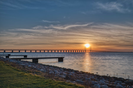 Sunset on the Oresund Bridge (Oresundsbron) in the Baltic Sea. The road rail overpass connects Malmo to Copenhagen across the Oresund Strait and border commuters or frontier workers cross it dailyの写真素材