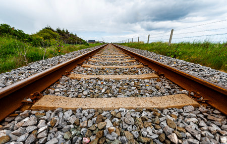 Railway tracks seem to point towards infinity. Linear railroad points toward a faraway location in a...