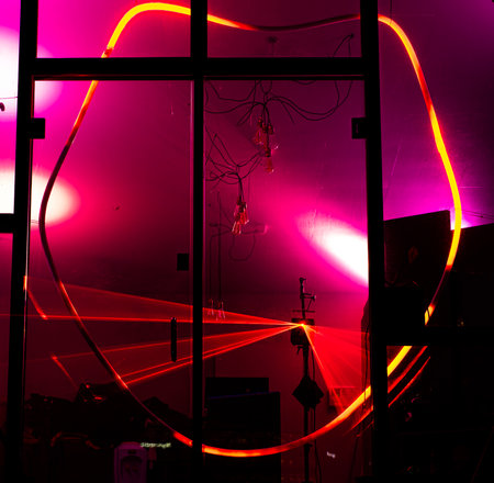 Red deformed round neon with red laser lights flashing behind the strange shape seems the interior...