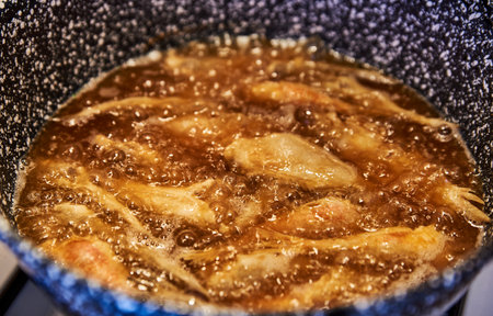 Golden small fish sizzle in hot oil, capturing a rustic southern Italian tradition. Crisping in a speckled pan, this scene reflects heritage, simplicity, of Mediterranean cuisineの写真素材